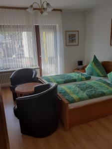 een slaapkamer met 2 bedden en een tafel en stoelen bij Gästehaus Brockmüller in Ensch