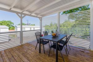 a dining room with a table and chairs on a porch at Zelena Laguna Mobile Homes in Poreč +36 photos