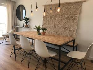 a dining room with a wooden table and white chairs at BEACH LOFT 9 luxury appartment with ocean view in Blankenberge