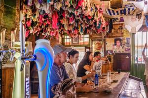 Eine Gruppe von Menschen sitzt an einer Bar in einem Restaurant in der Unterkunft Paternoster Hotel in Paternoster
