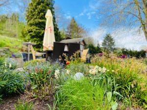 a garden with flowers and an umbrella in the background at Pension Katharinenschule in Eisenach