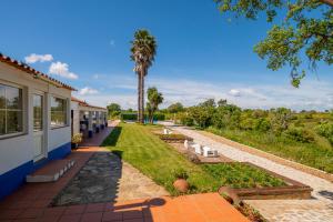 a house with a garden and a palm tree at Monte Pedras Negras in São Luis