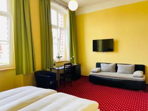 ein Hotelzimmer mit einem Bett und einem Sofa in der Unterkunft Pension Katharinenschule in Eisenach