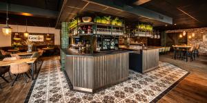 a bar in a restaurant with tables and chairs at Grand Café Goejje voorheen Oranje Hotel in Meijel