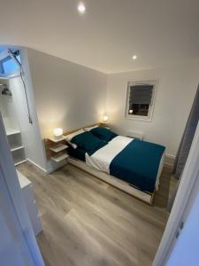 - une chambre avec un lit doté de draps bleus et une fenêtre dans l'établissement Annecy coeur de ville et du lac, à Annecy