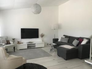 uma sala de estar com um sofá e uma televisão de ecrã plano em Tyylikäs rivitaloasunto Lohjalla em Lohja