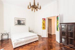 sypialnia z białym łóżkiem i żyrandolem w obiekcie Vatican Large Comfortable Apartment w Rzymie