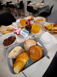 una mesa con una bandeja de cruasanes y otros productos para el desayuno en Hotel Astoria, en Carcassonne