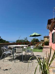 patio con tavolo, sedie e ombrellone di Villa paradiso a Maratea