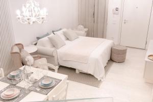 - une chambre blanche avec un grand lit et une table dans l'établissement The Suite Home Verona, à Vérone