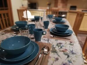 uma mesa com tigelas azuis e pratos em Holiday House Kinveachy em Aviemore