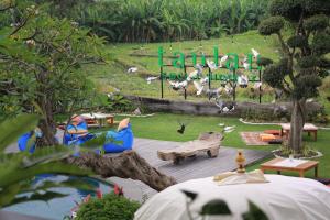 a playground in a park with a grassy field at Taulan Villa by Social Hideout in Kerobokan