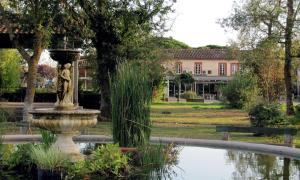 una fontana in mezzo a un laghetto in un parco di Best Western Plus Le Canard sur le Toit a Colomiers