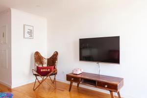 uma sala de estar com uma cadeira, uma mesa e uma televisão em Lisbon Chillout Apartments em Lisboa