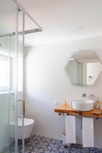 a bathroom with a sink and a toilet and a mirror at Lisbon Chillout Apartments in Lisbon