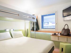 una camera d'albergo con letto e finestra di ibis budget Bordeaux Centre Mériadeck a Bordeaux