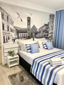 a bedroom with two beds with a mural of a city at Family Resort Urania in Baška Voda