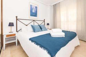 una camera da letto con un grande letto con una coperta blu di Benalmadena Sol y Mar a Benalmádena