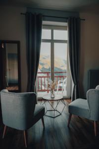 a living room with two chairs and a table and a window at Hotel Splendide in Champex