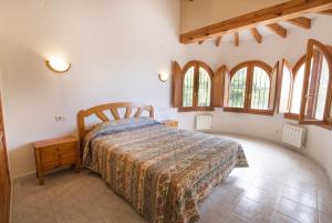 1 dormitorio con 1 cama y algunas ventanas en Villa Empedrola, en Calpe