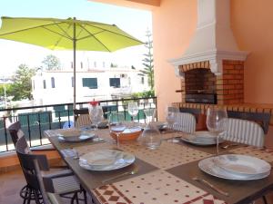 a table with wine glasses and an umbrella on a balcony at Globo by Check-in Portugal in Albufeira