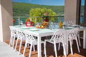 d'une table et de chaises blanches sur un balcon. dans l'établissement Villa Bagatelle - Vision Luxe, à Veyrier-du-Lac