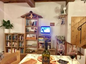 a dining room with a table with wine glasses and a television at Cottage Barbara with aircon, beautiful sea view by ToscanaTour in Casale Marittimo
