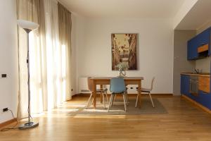 ein Esszimmer mit einem Tisch und einem blauen Stuhl in der Unterkunft Yourbanflat Porta Altinate in Padua