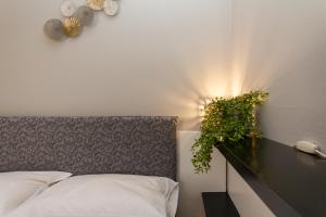 sypialnia z łóżkiem z lampką na ścianie w obiekcie Yourbanflat Giotto w Padwie