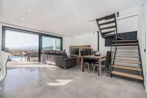a living room with a spiral staircase and a table at Villa Corb Mari I by Sealand Villas in Muro