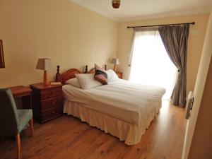 a bedroom with a large bed and a window at Kilkee Holiday Homes Ground Floor in Kilkee
