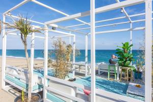 a man sitting at a table next to the beach at HomeHolidaysRentals Royal in Pineda de Mar