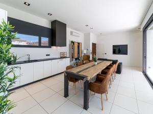 an open kitchen with a wooden table and chairs at Villa Blanca in L'Escala