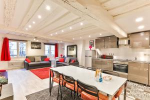eine Küche und ein Wohnzimmer mit einem Tisch und Stühlen in der Unterkunft 100 - Luxury 2 Bedroom - Beaubourg Marais in Paris