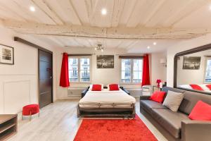 a bedroom with a bed and a couch and red pillows at 100 - Luxury 2 Bedroom - Beaubourg Marais in Paris