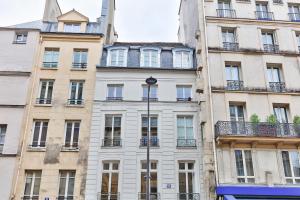 a tall building with a clock on the side of it at 100 - Luxury 2 Bedroom - Beaubourg Marais in Paris