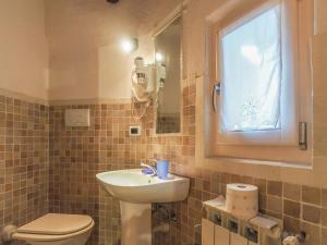 a bathroom with a sink and a toilet and a window at Casa Cristina in Campitello di Fassa