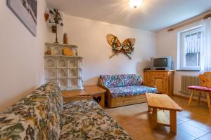 un soggiorno con divano e sedia di Residence Sas de le Undesc a Soraga