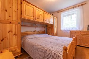 una camera da letto con un letto con armadi in legno e una finestra di Residence Sas de le Undesc a Soraga