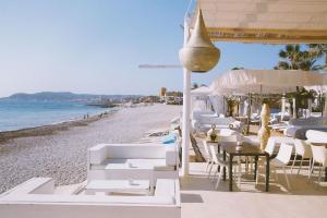 a beach with white chairs and tables and the ocean at Holiday Home Calas in Jávea