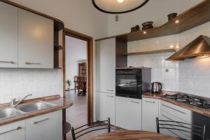 a kitchen with white cabinets and a sink and a stove at La Casetta Dei Daini - Affitti Brevi Italia in Orio al Serio