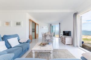 un soggiorno con divano blu e tavolo di YourHouse Solmarina Son Serra a Son Serra de Marina