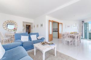 un soggiorno con divano blu e tavolo di YourHouse Solmarina Son Serra a Son Serra de Marina