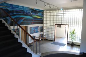 a hallway with a staircase with a large painting on the wall at Kverna Guesthouse in Skogar