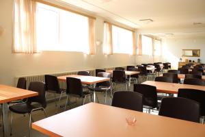 uma sala de aula vazia com mesas, cadeiras e janelas em Kverna Guesthouse em Skógar