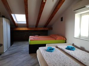 a attic room with two beds and two windows at Apartments Villa Irena in Koper