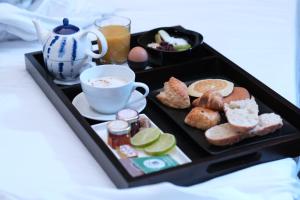 a tray of breakfast foods and a cup of coffee at BDX Hôtel - Gare Saint-Jean in Bordeaux