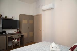 a bedroom with a bed and a desk and a television at Belvedere 75 in Naples