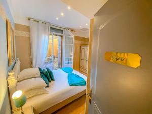 a small bedroom with a bed with a window at Hotel Relais Du Postillon in Antibes