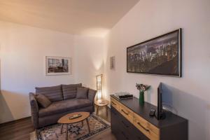 ein Wohnzimmer mit einem Sofa und einem TV in der Unterkunft Apartment Eva in Bozen